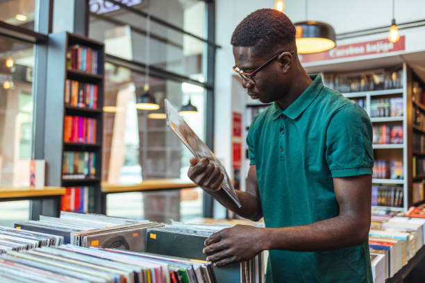 istock Young man with vinyl record in store 1466614195