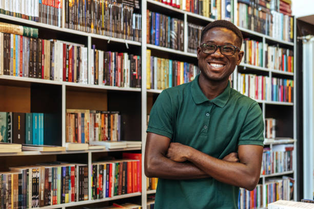 istock Handsome afro student posing on bookshelves background 1466614878