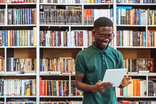 istock Young happy college man using digital tablet at the university 1466615097