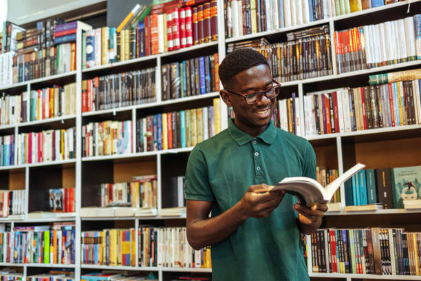 istock University student doing homework in school library and smiling. 1466615192