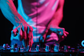 Party DJ mixing musical tracks. Close up photo of club disc jockey adjusting volume on sound mixer