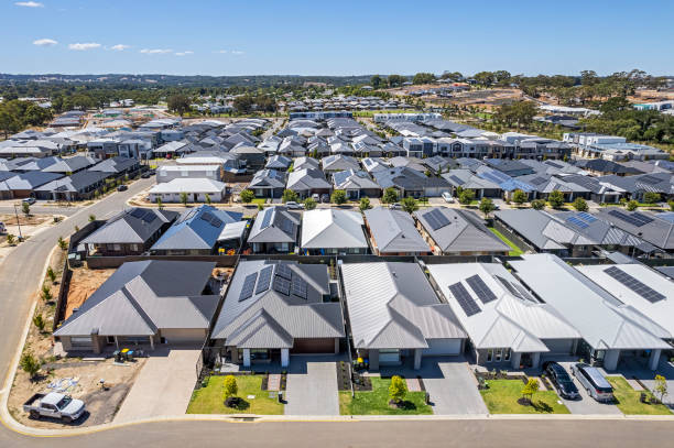 Low aerial close view new dense rural housing development, mostly grey roofing, some green landscaping, young trees Low aerial close view new dense rural housing development, mostly grey roofing, some green landscaping, young trees. Rows of houses of various architectural styles with shades of grey roofing in rural urban sprawl, some still under construction.  Tightly-packed houses with small front and back yards and few if any trees. Some solar panels installed. Mt Barker near Adelaide, South Australia adelaide stock pictures, royalty-free photos & images