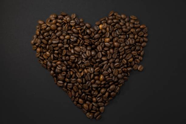 istock Coffee beans in a heart shape on black background 1466616412