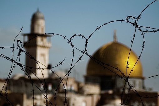 A tense atmosphere in Jerusalem, Israel.\nThe temple mountain behind the barbed wire.