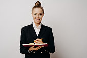 Business woman in dark suit writing in note book