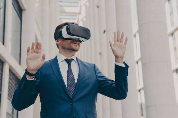 istock Businessman using VR headset for virtual reality game for work, standing outdoors 1466620723