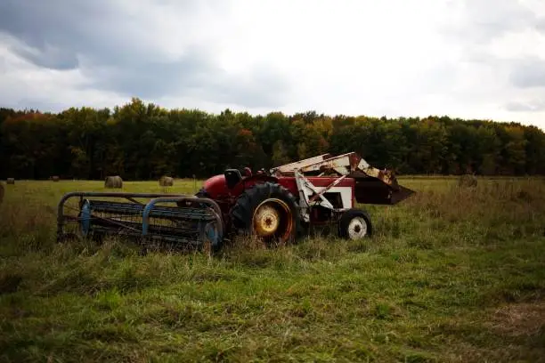 Photo of Haymaker tractor working on a field during daytime