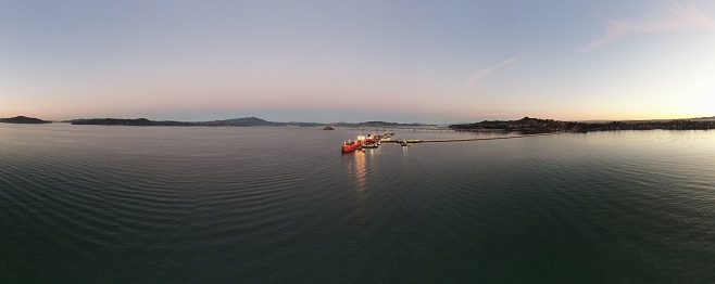 A Drone shot of a bay in a lake with rocky shore under dusk sky at sunset