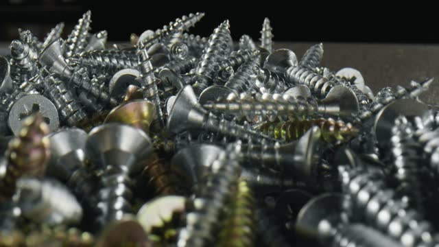 Big heap of shiny metallic and brazen  screws - close up