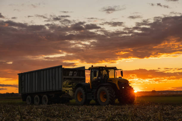 istock Tractor with trailer parked on agricultural field during sunset 1466628209
