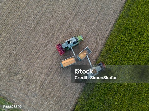 istock Aerial View of two combine harvester filling grain into two trailers 1466628309