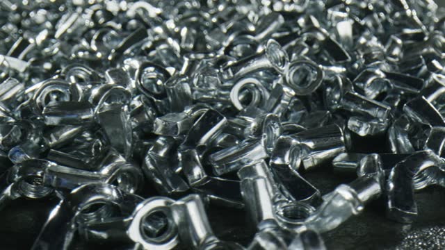 Dozens of scattered metal nuts with fasteners  - close up