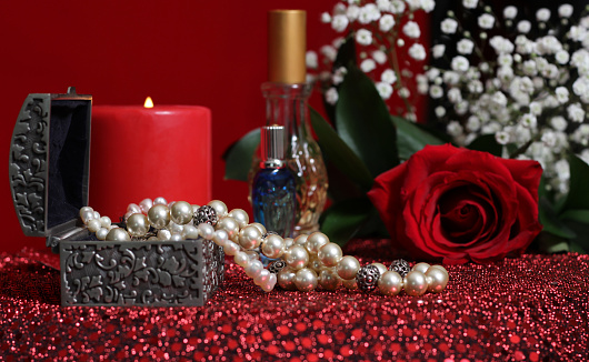 Candle and Red Rose With Perfume on Red Velvet Background