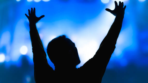 istock Silhouette of a man with concert stage lights 1466632797