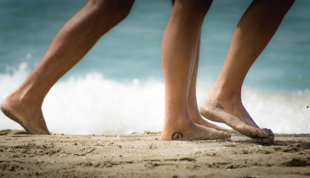 istock Selective closeup of bare feet on a sandy beach 1466633285
