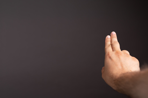 A closeup of a businessman pointing his finger on the black surface