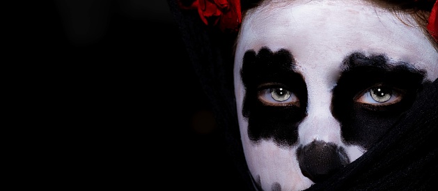 A panoramic shot of a young Caucasian lady from Spain with a Halloween sugar skull makeup