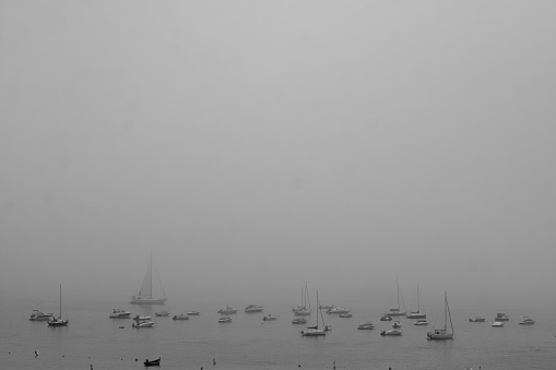 Black and white photograph of boats in the bay of Sesimbra on a foggy morning.