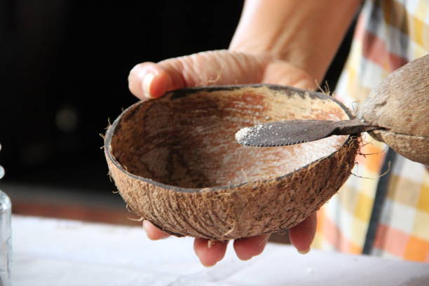 istock Person adding sugar in a coconut bowl 1466639529