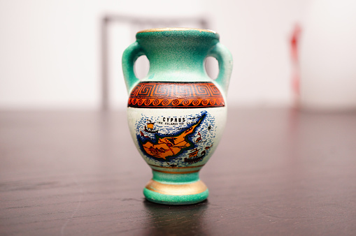 A close up shot of a beautiful vase with a map drew on it with blurry background