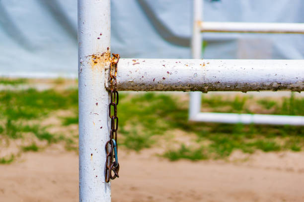 istock Rusty old chain hanging on a white metal barrier 1466640412