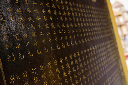 A closeup of Chinese oriental golden characters on the wall in Tran Quoc Pagoda in Vietnam
