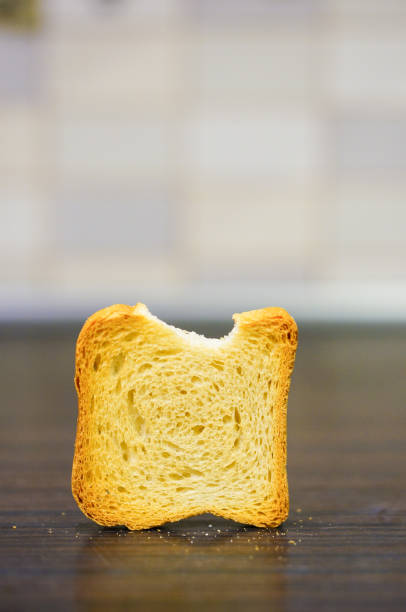 Vertical shot of a bit toasted bread on a wooden table