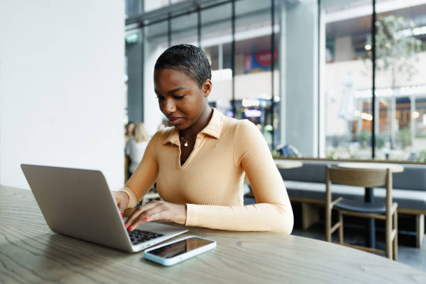 istock Young african woman freelancer working on laptop while sitting in coworking 1466645575