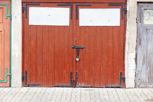 An old red wooden door secured with a lock in a building