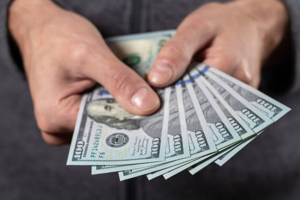 istock American 100 dollars bank note in hand close up 1466646886