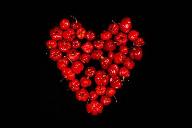Photo of Closeup of heart-shaped Red chilli peppers on black background