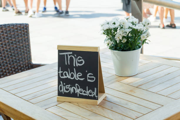 istock Wooden blackboard as table sign on a sanitized table in a restaurant. 1466649141