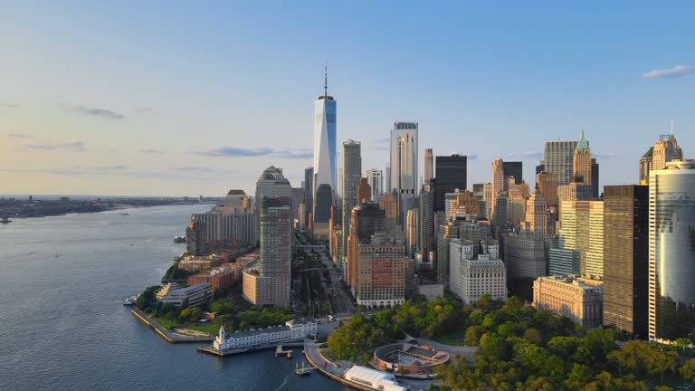 Financial District of New York, Aerial Shoot in Downtown Manhattan, showing the Sun reflections during the Sunset from Seaport Waterfront to Hudson River.