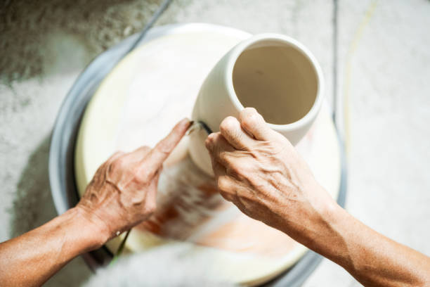 overhead view on vietnamese male hands shaping vase at pottery wheel in manufacture