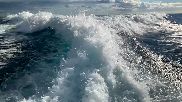 Boat wake on the blue ocean