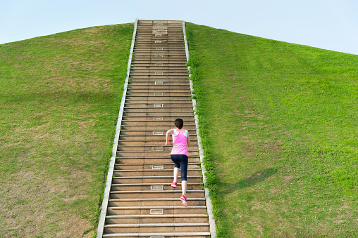 Woman running up the stairs in the park.