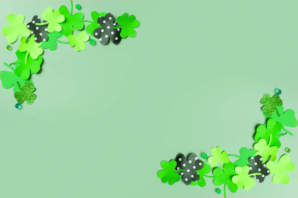 istock St. Patrick's Day minimalistic concept. Paper clover leaves on colored background with copy space 1466654095