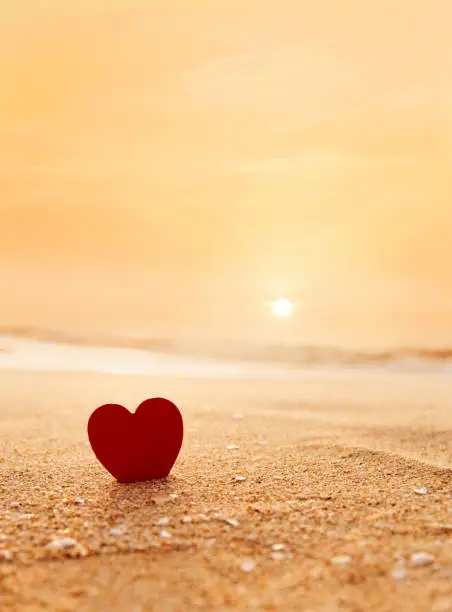 Photo of Red heart shape on the beach at sunset