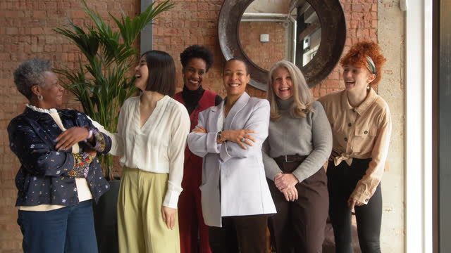 Slow motion of cheerful multiethnic mixed age businesswomen laughing and smiling, supporting International Women's Day