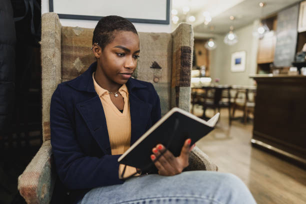 istock Beautiful african girl making notes in diary in cafeteria. 1466667573