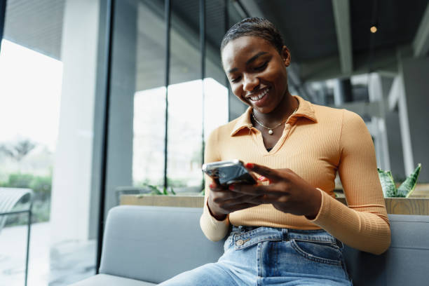 istock Young african woman using smart phone in a modern cafe 1466668081
