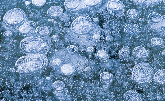 Close up of frozen air pockets on a lake