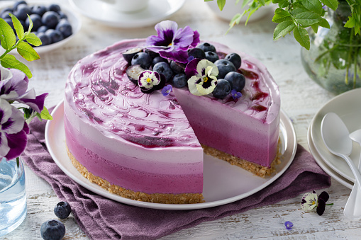no baked blueberry layered cheesecake, ombre mousse cake, decorated with fresh berries and edible viola flowers