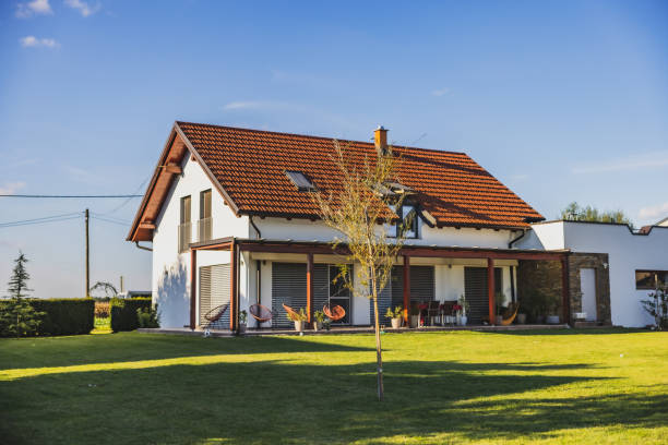 istock Modern house with terrace on the countryside,large backyard,young tree in front,clear sky in the background 1466673646