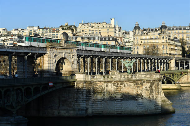 Paris, France-02 07 2023: Aerial metro train passing over the Bir-Hakeim railway bridge above the Seine river in Paris, France.