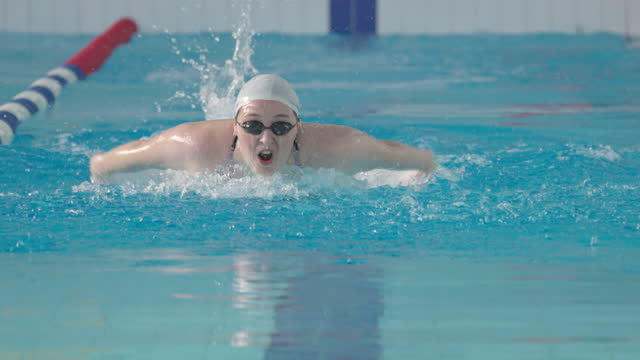 Young woman, a professional swimmer, swims with a butterfly style