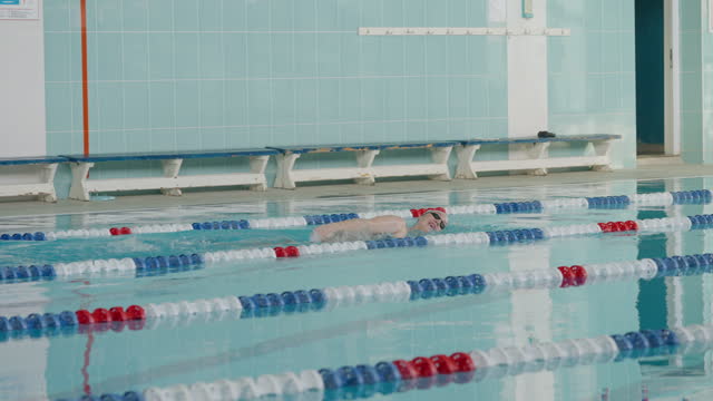 Young plump woman, a professional swimmer, swims in the crawl style.