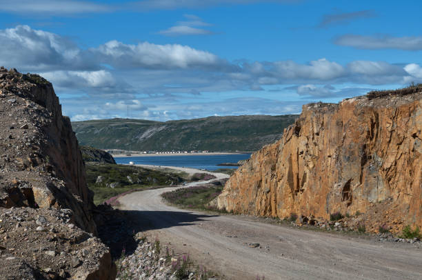 istock Winding dirt road in a mountainous area under a summer cloudy sky 1466676608