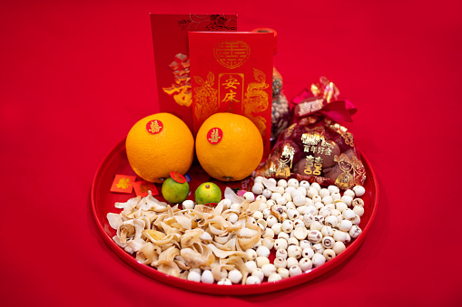 In traditional Chinese weddings, red dates, peanuts, longan, lotus seeds, oranges, and red envelopes are placed on the bed in the wedding room, symbolizing the wish for an early birth