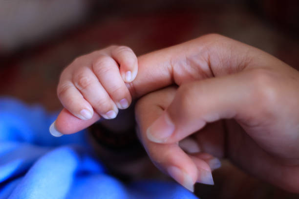 istock Baby's tiny hand holding mother's finger 1466685071